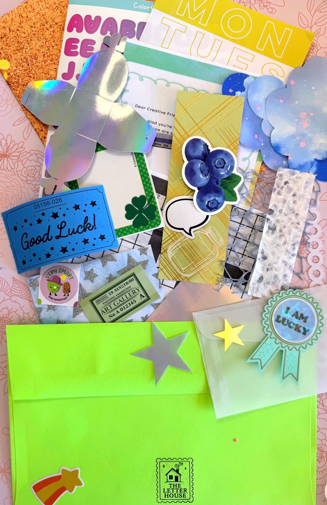 A collage mail kit with colorful paper, textures, and creative prompts