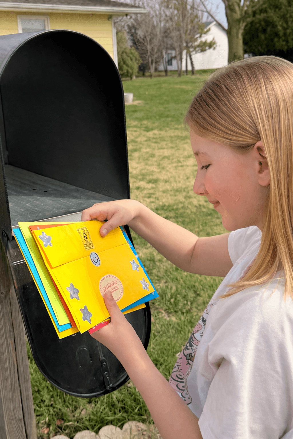 A child happily discovering colorful Letter House mail in a mailbox